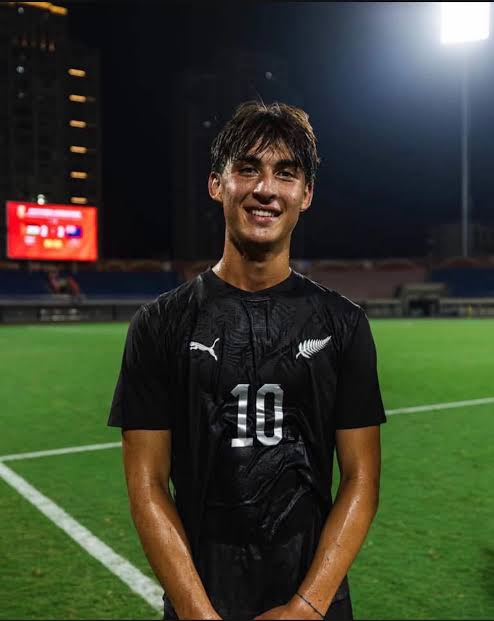Stipe Ukich smiling in New Zealand's black number 10 shirt after a night match