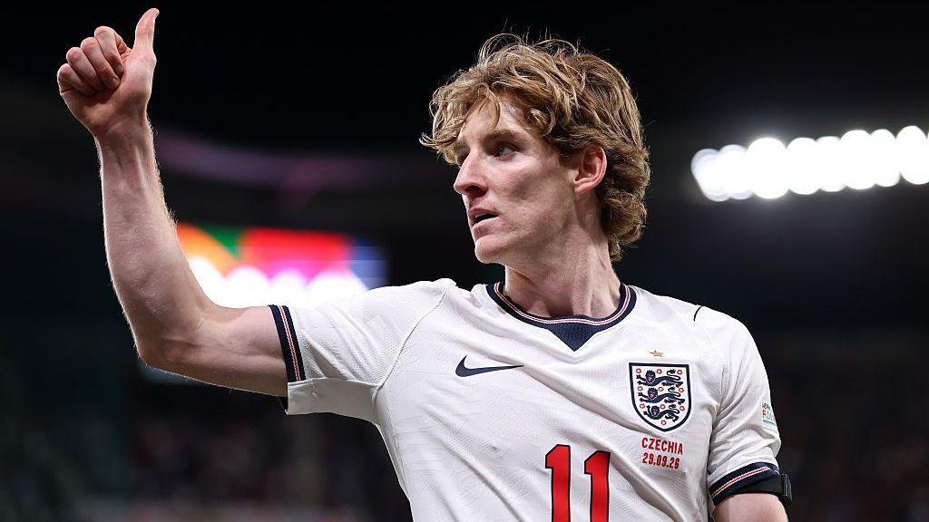 Anthony Gordon gives a thumbs-up in an England shirt