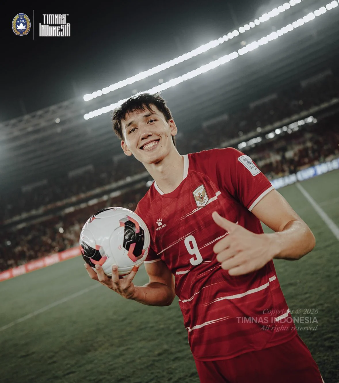 Mitchell Baker in Indonesia's red shirt holding a match ball and giving a thumbs up at Gelora Bung Karno